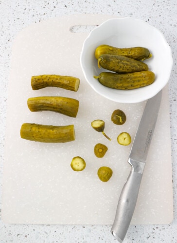 Pickles on a cutting board with the ends cut off on each side