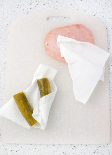 Pickles and ham being padded dry with paper towel