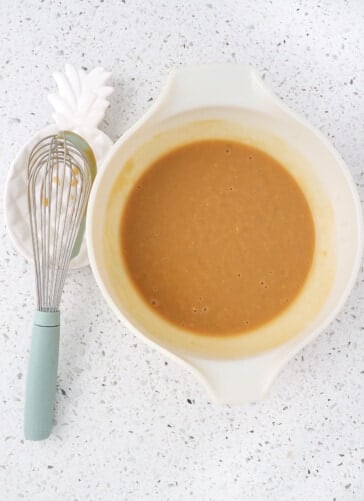 Four ingredients mixed together in a bowl with a whisk ready to be poured over the crock pot pork chops