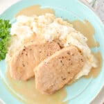 Five ingredient pork chops ready for dinner drizzled with gravy on mashed potatoes