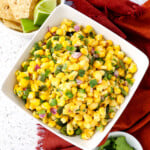 Copycat corn salsa Chipotle Style in a bowl with fresh cilantro and chips on the side