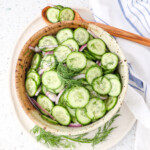 Cucumber salad and a bowl ready to be served with fresh mint and onions tossed in a honey vinaigrette dressing