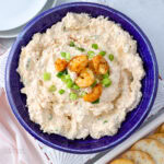 cream cheese shrimp dip topped wit whole shrimp and onions