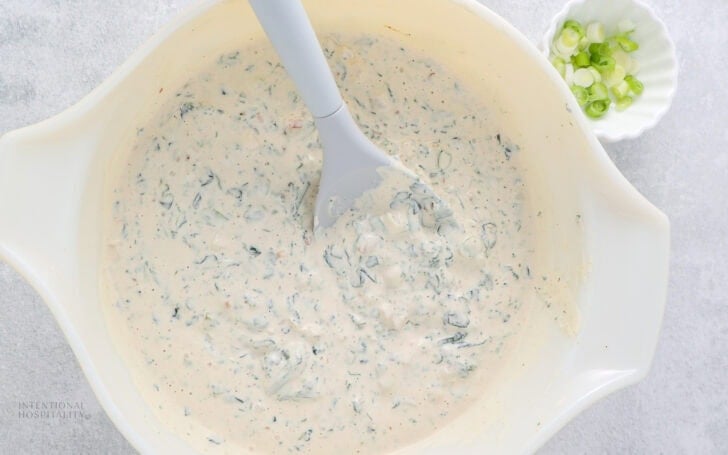 knorr vegetable dip that has been stirred in a bowl with green onions and a small bowl next to it