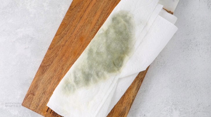 Spinach being dried between two pieces of paper towel