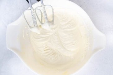 cool whip frosting being mixed in a bowl.