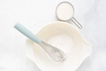 pudding mix in a bowl with milk and whisk