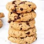 A stack of five chocolate chip cookies on a white background. The cookies look thick and chunky with visible chocolate pieces, creating a tempting appearance.