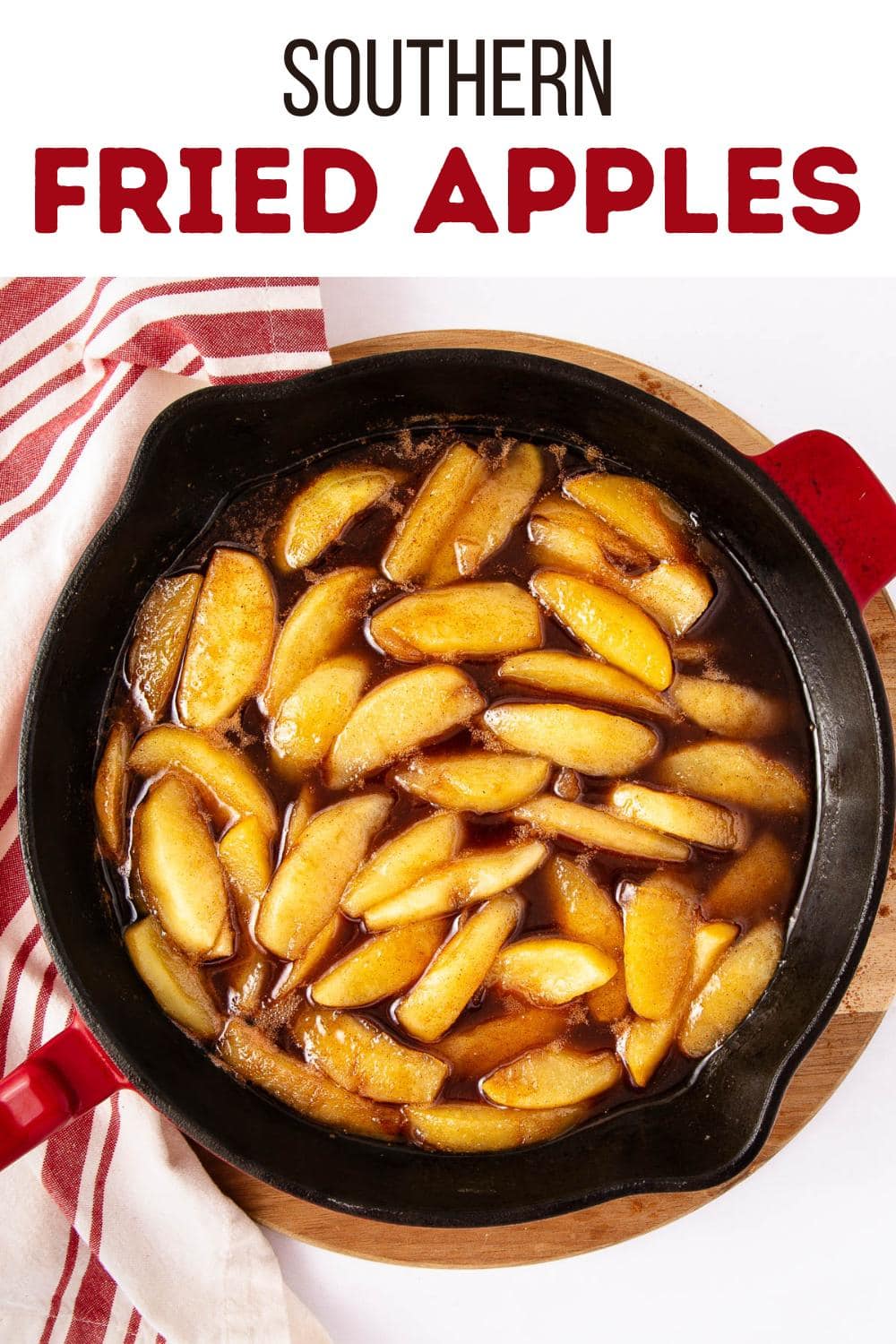 A cast iron skillet filled with sliced apples cooked in a brown sauce, sitting on a round wooden board with a red and white striped towel beside it. Text above reads "Southern Fried Apples.