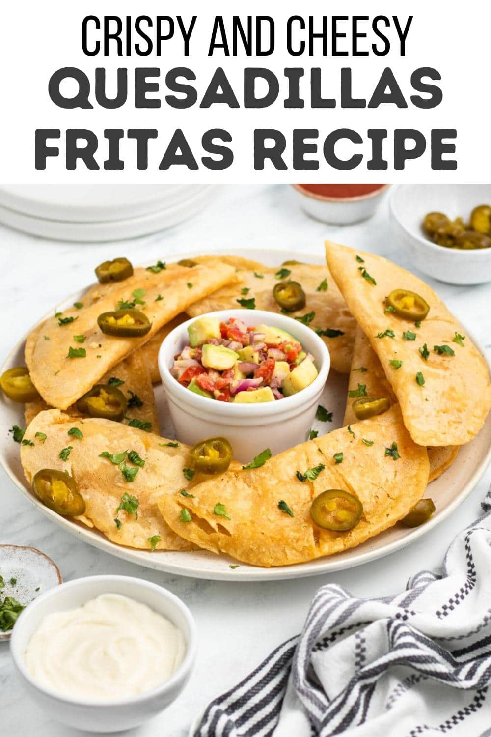 A plate of crispy, cheese-filled quesadillas garnished with jalapeño slices and chopped herbs, surrounding a bowl of salsa. Text above reads: "Crispy and Cheesy Quesadillas Fritas Recipe.