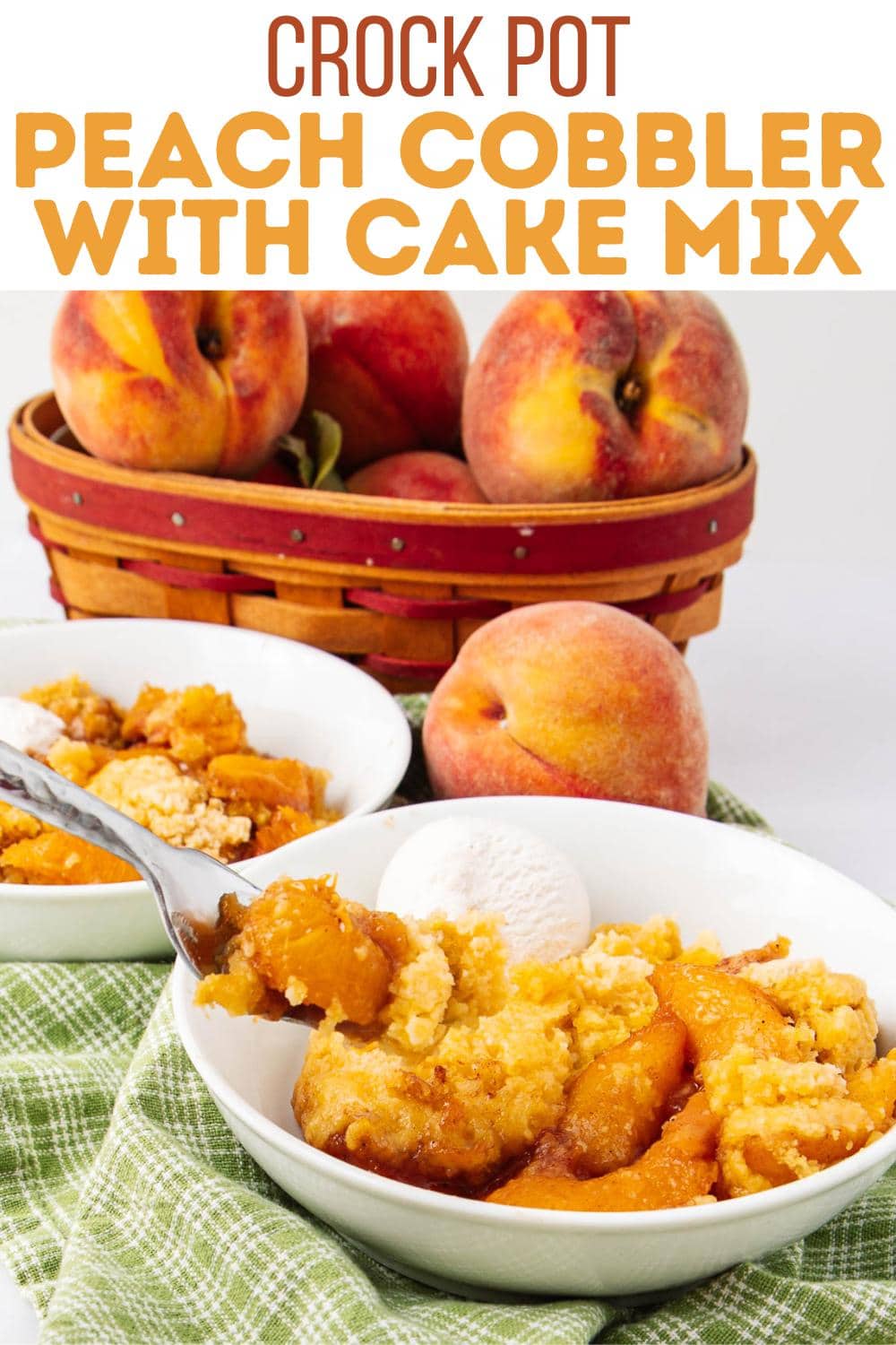 A bowl of peach cobbler topped with a scoop of vanilla ice cream sits on a green cloth, with fresh peaches and a basket of peaches in the background. A fork lifts a bite from the cobbler. Bold text reads: Crock Pot Peach Cobbler with Cake Mix.