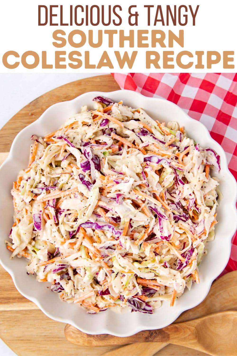 A bowl of colorful southern coleslaw with shredded cabbage and carrots sits on a wooden board next to a red and white checkered cloth. Text above reads, "Delicious & Tangy Southern Coleslaw Recipe.