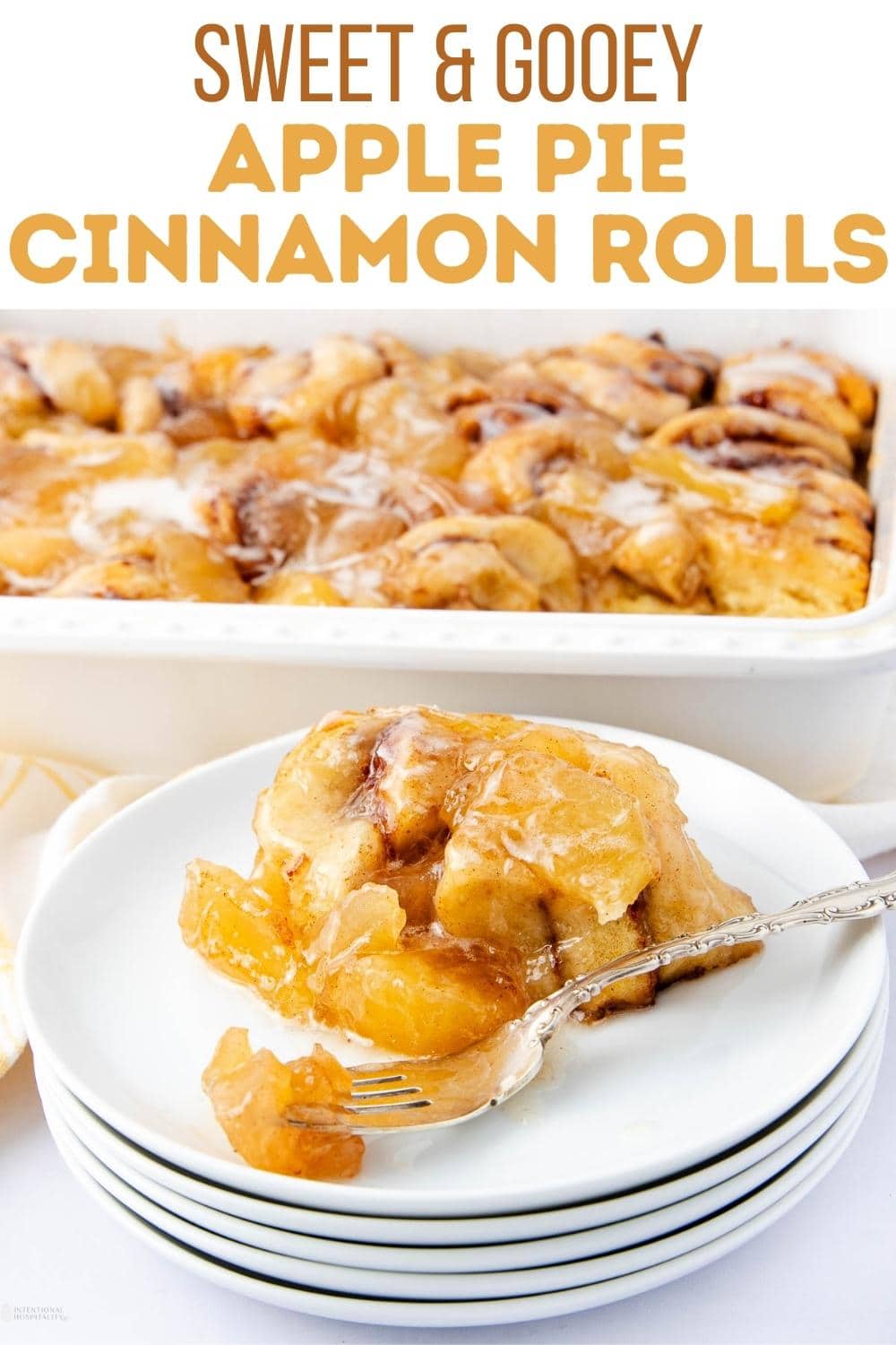 A plate with a serving of gooey apple pie cinnamon rolls sits in front of a casserole dish filled with more cinnamon rolls. Text above reads, "Sweet & Gooey Apple Pie Cinnamon Rolls.