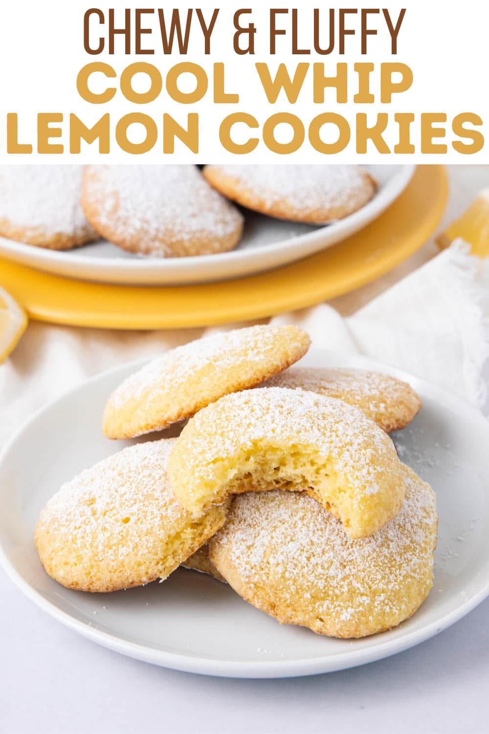 A plate of chewy lemon cookies dusted with powdered sugar, with one cookie showing a bite taken out. More cookies are on a plate in the background. Text above reads "Chewy & Fluffy Cool Whip Lemon Cookies.