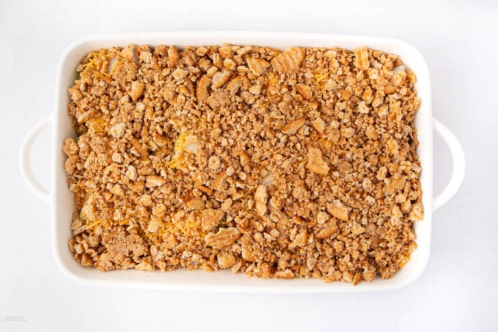 A white rectangular baking dish filled with a golden-brown, crumbly casserole topping, viewed from above on a white background.