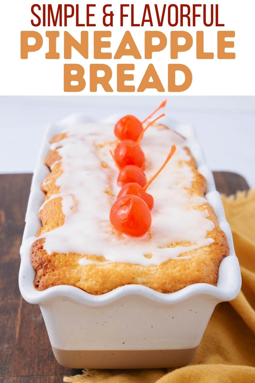 A loaf of pineapple bread topped with white icing and four maraschino cherries, displayed in a white scalloped baking dish. The text above reads, "Simple & Flavorful Pineapple Bread.