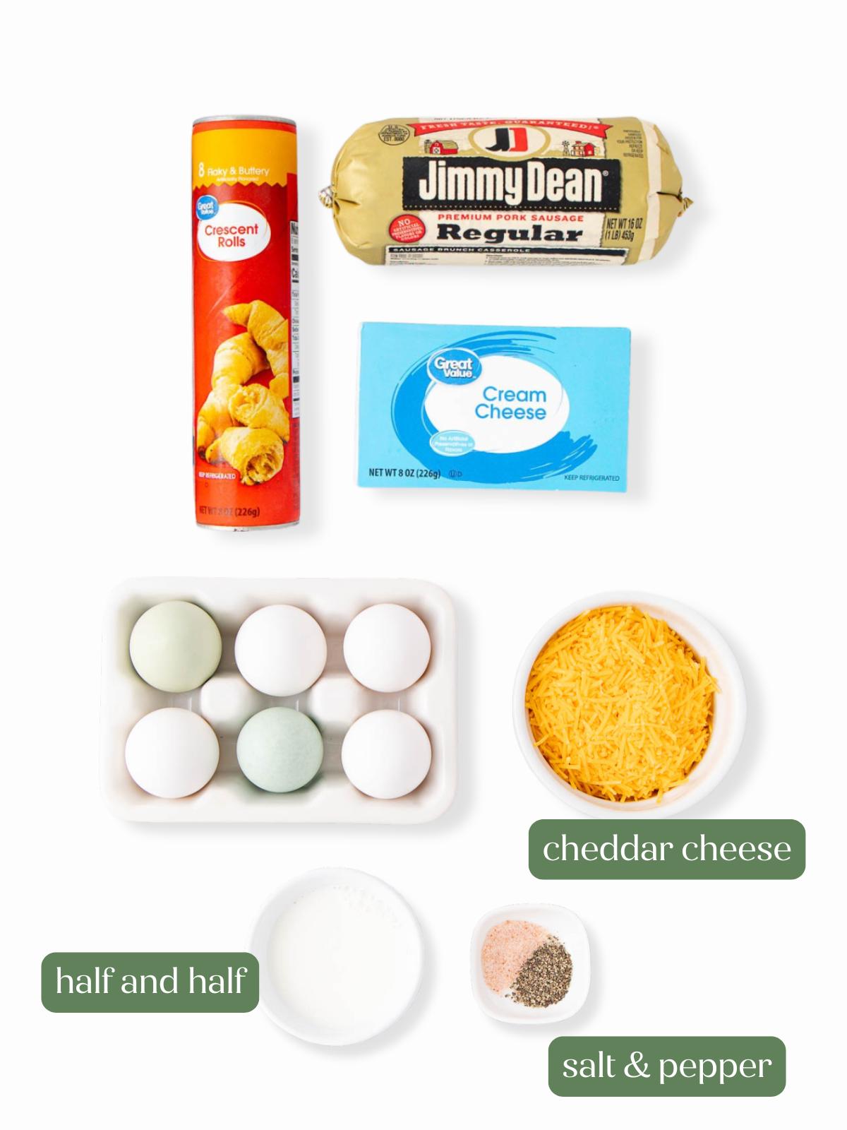 Ingredients for a breakfast recipe: a can of crescent rolls, a tube of sausage, a box of cream cheese, six eggs, shredded cheddar cheese, a small bowl of half and half, and salt and pepper.