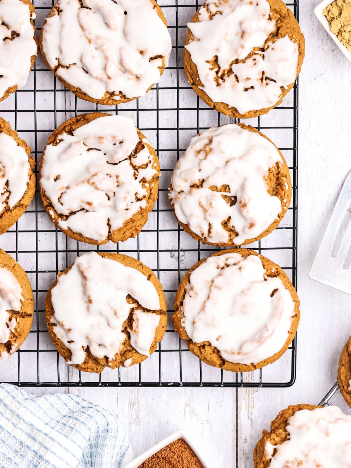 Glazed ginger molasses cookies arranged on a wire cooling rack.